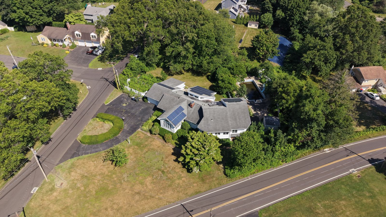Aerial view of the home and Long Hill neighborhood in summer